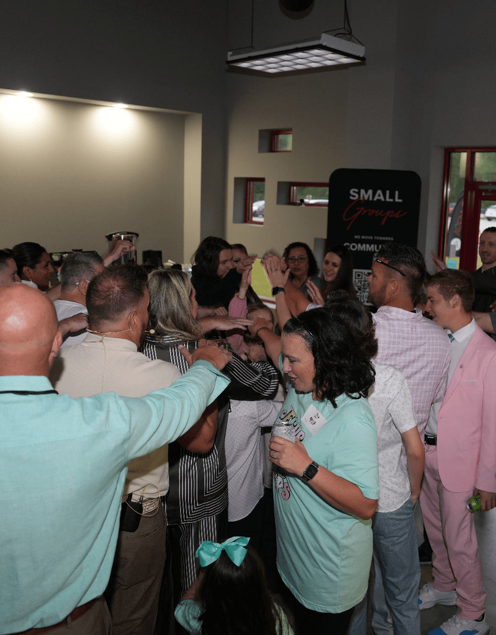 group of people praying and laying hands on someone