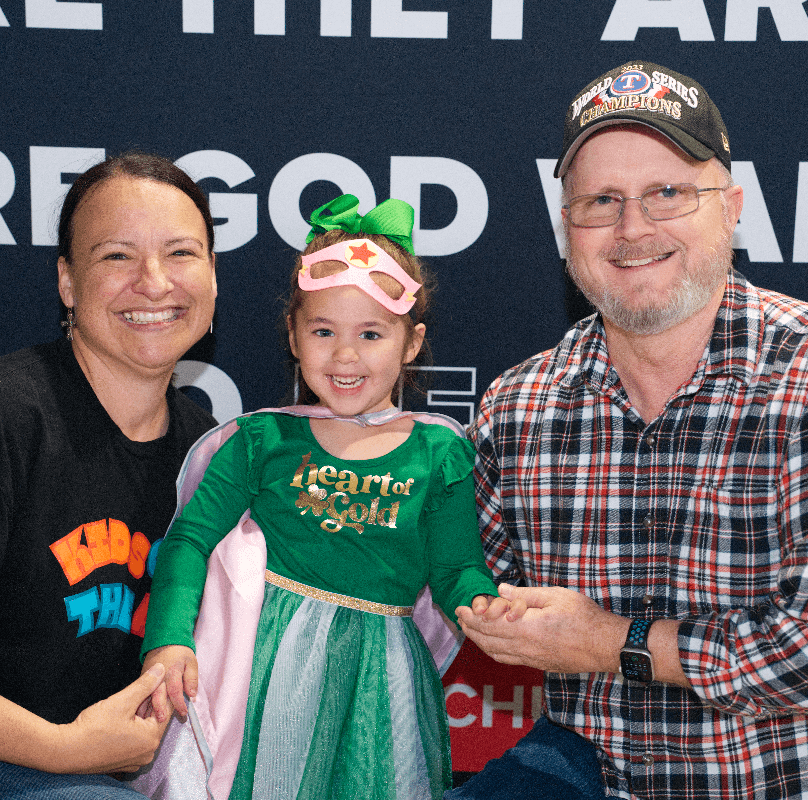 man and woman with little girl wearing dress saying Heart of Gold