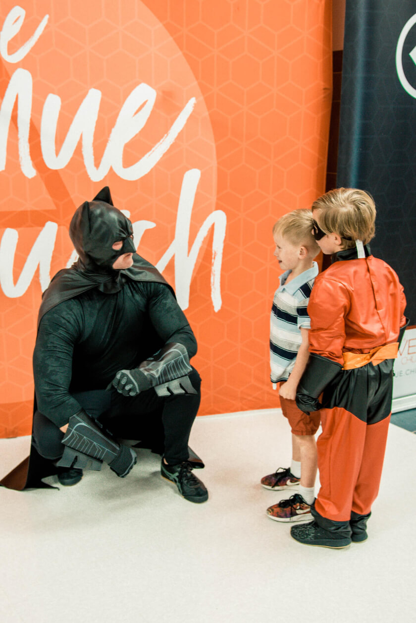 man in batman costume with kids